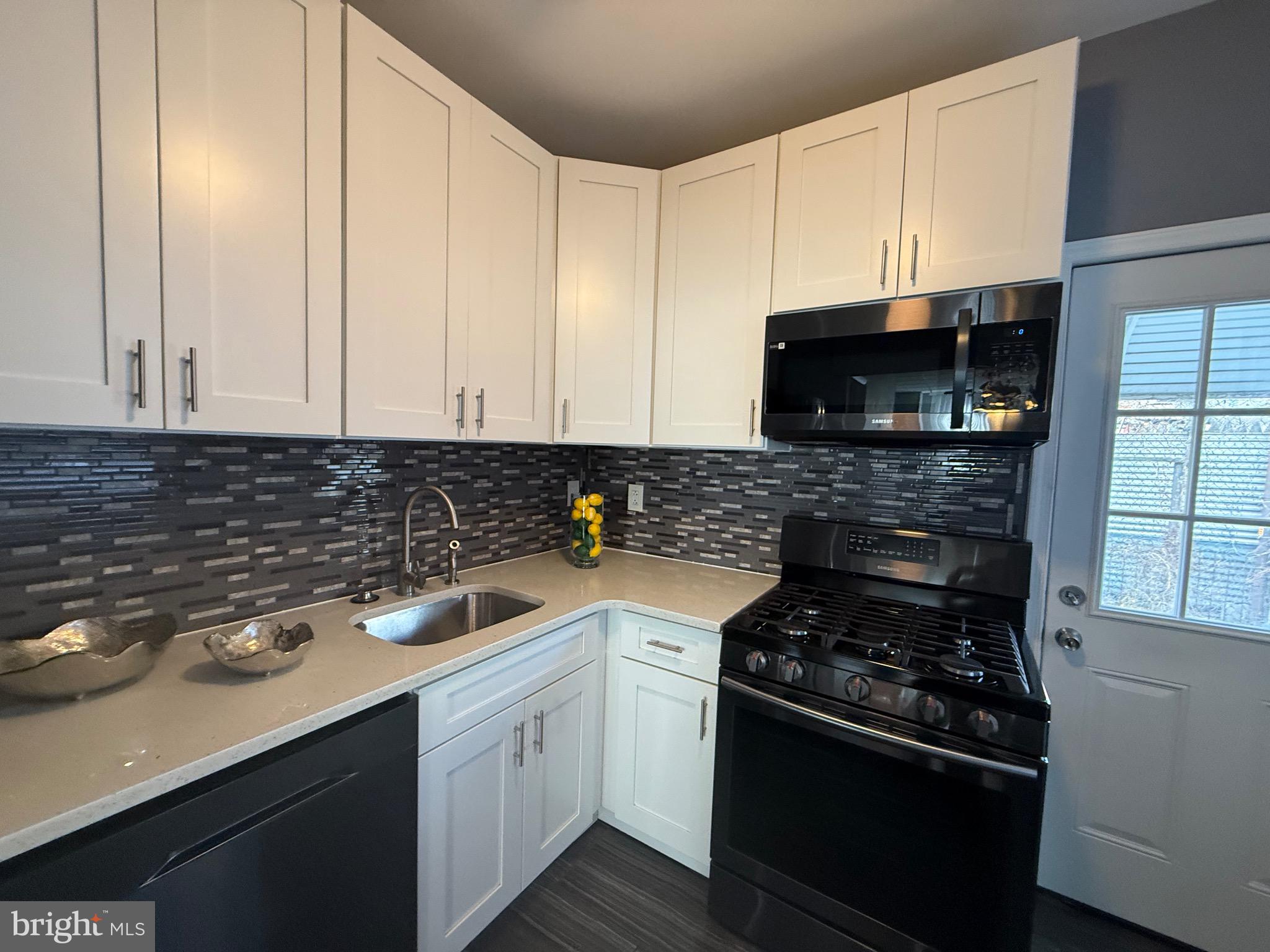 3146 Mercer Street Philadelphia, PA 19134 - Photo 4 of 22 a kitchen with a sink stove and microwave