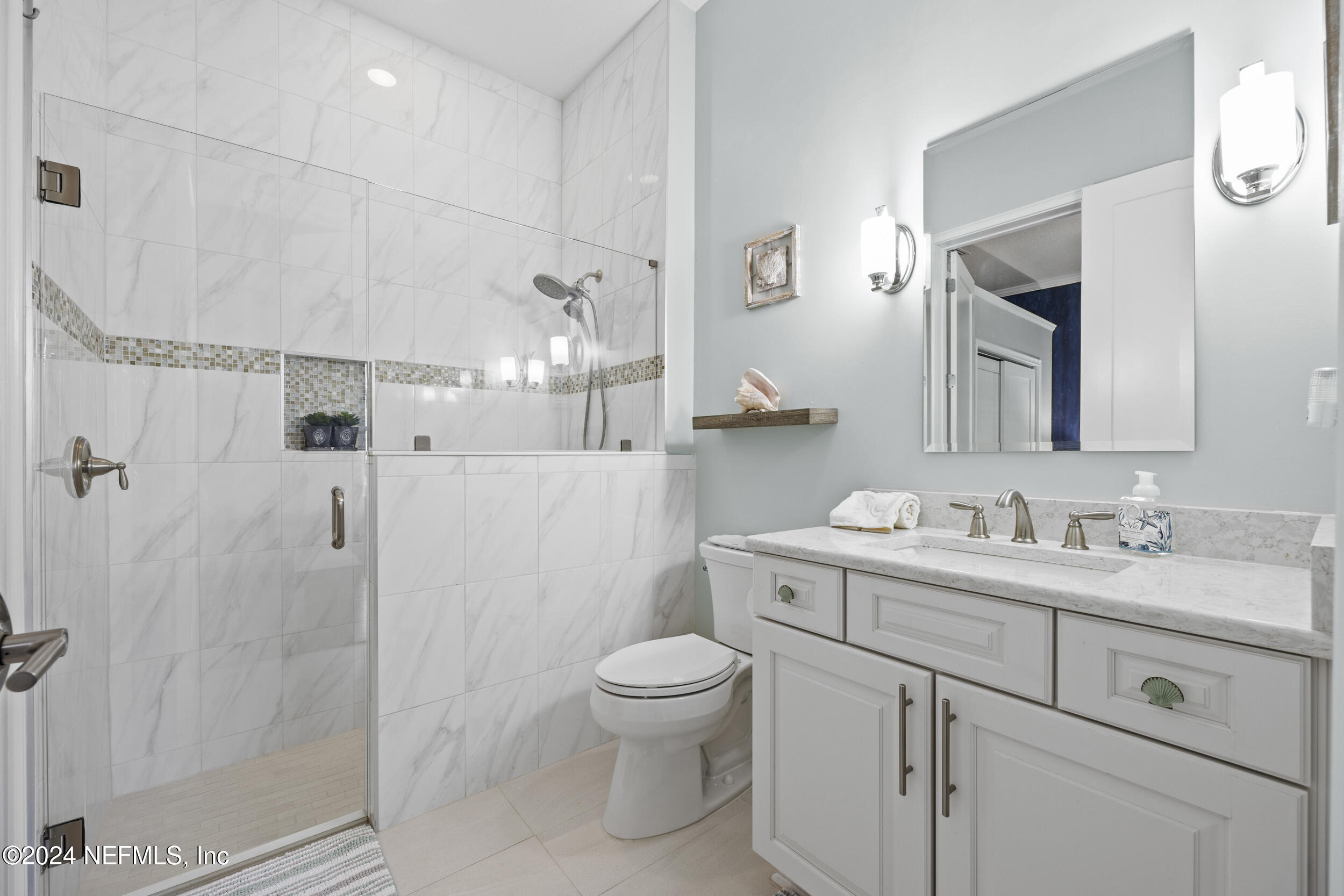 228 Rum Runner Way St. Johns, FL 32259 - Photo 30 of 97 a bathroom with a toilet a sink a glass door a shower a mirror and vanity