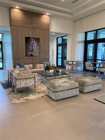 a living room with couches and kitchen view with wooden floor