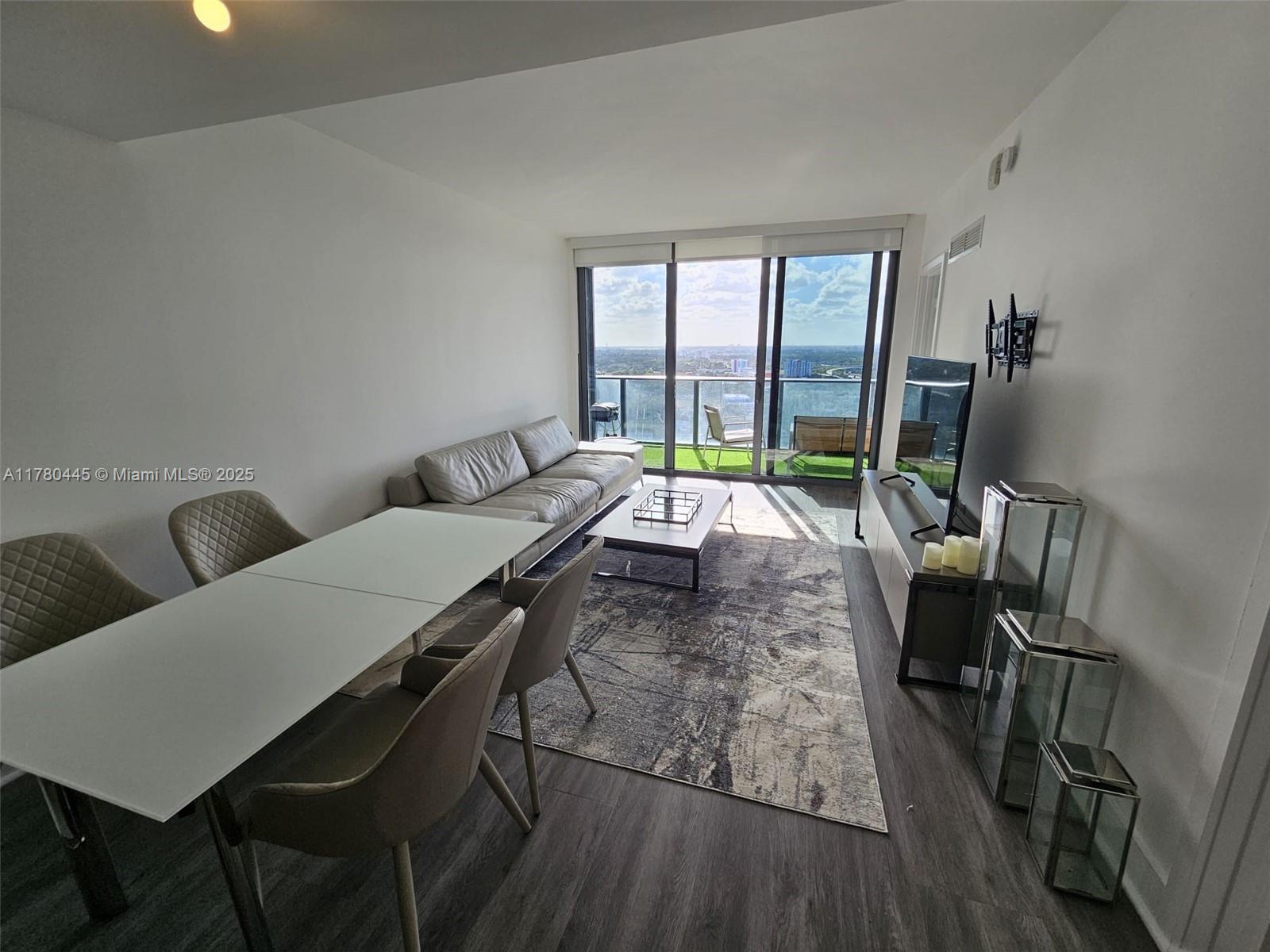 121 Northeast 34th Street, Unit 2511 Miami, FL 33137 - Photo 6 of 46 a living room with furniture rug and a large window