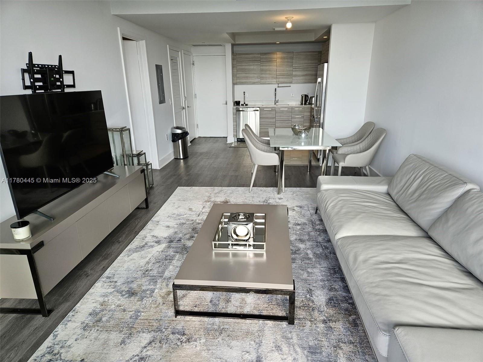 121 Northeast 34th Street, Unit 2511 Miami, FL 33137 - Photo 9 of 46 a living room with furniture and a flat screen tv