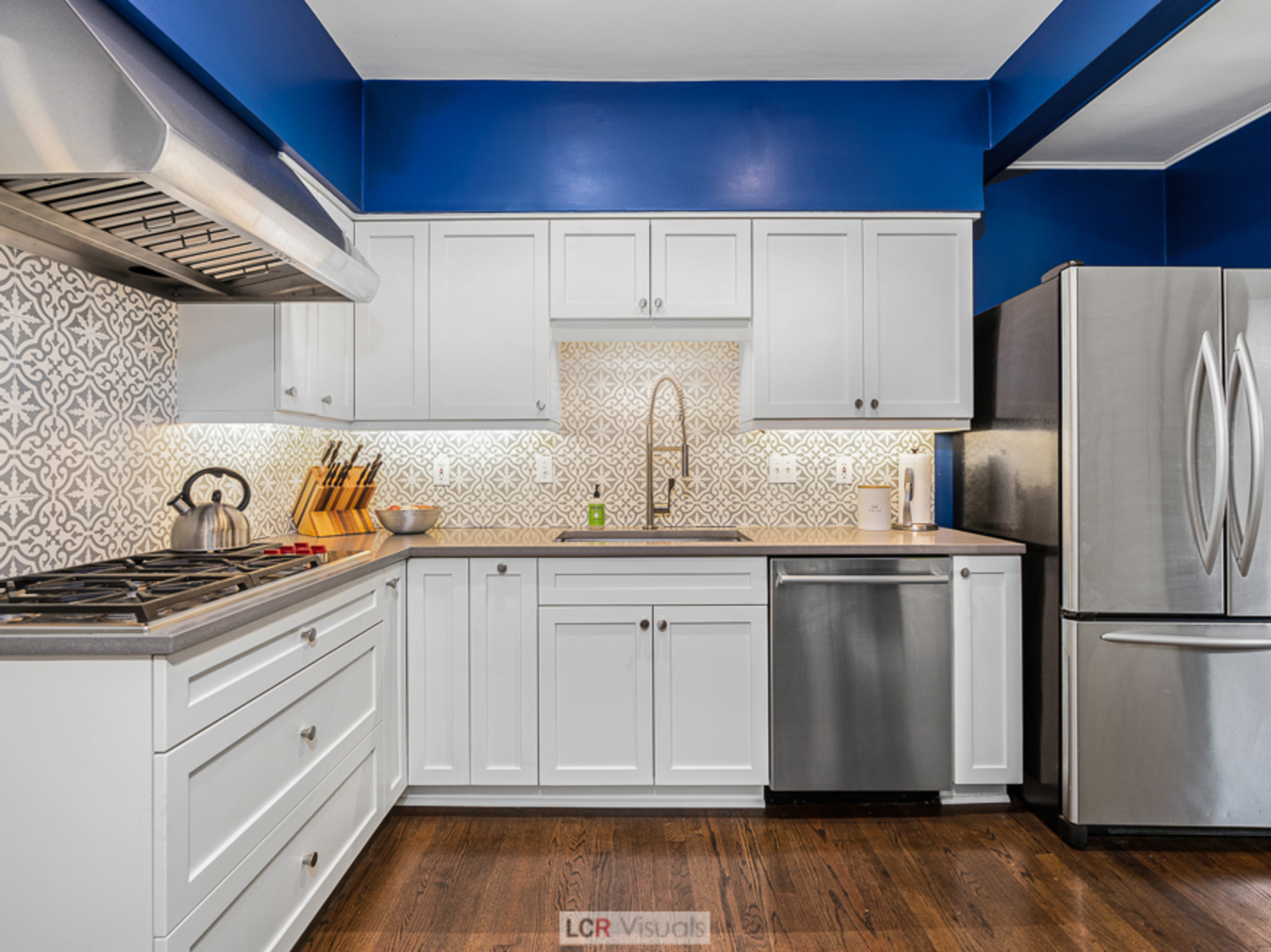 710 Bonnie Brae River Forest, IL 60305 - Photo 10 of 31 a kitchen with stainless steel appliances granite countertop a refrigerator a sink dishwasher a stove and white countertops with wooden floor