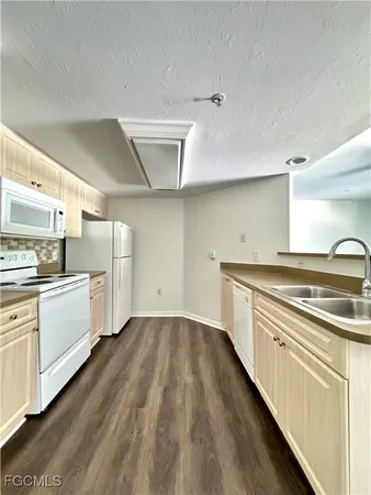 a kitchen with granite countertop white cabinets and white appliances