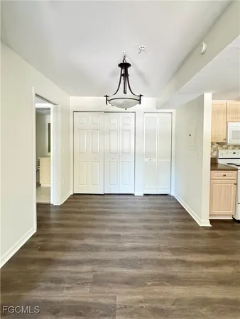 a view of empty room with wooden floor and window