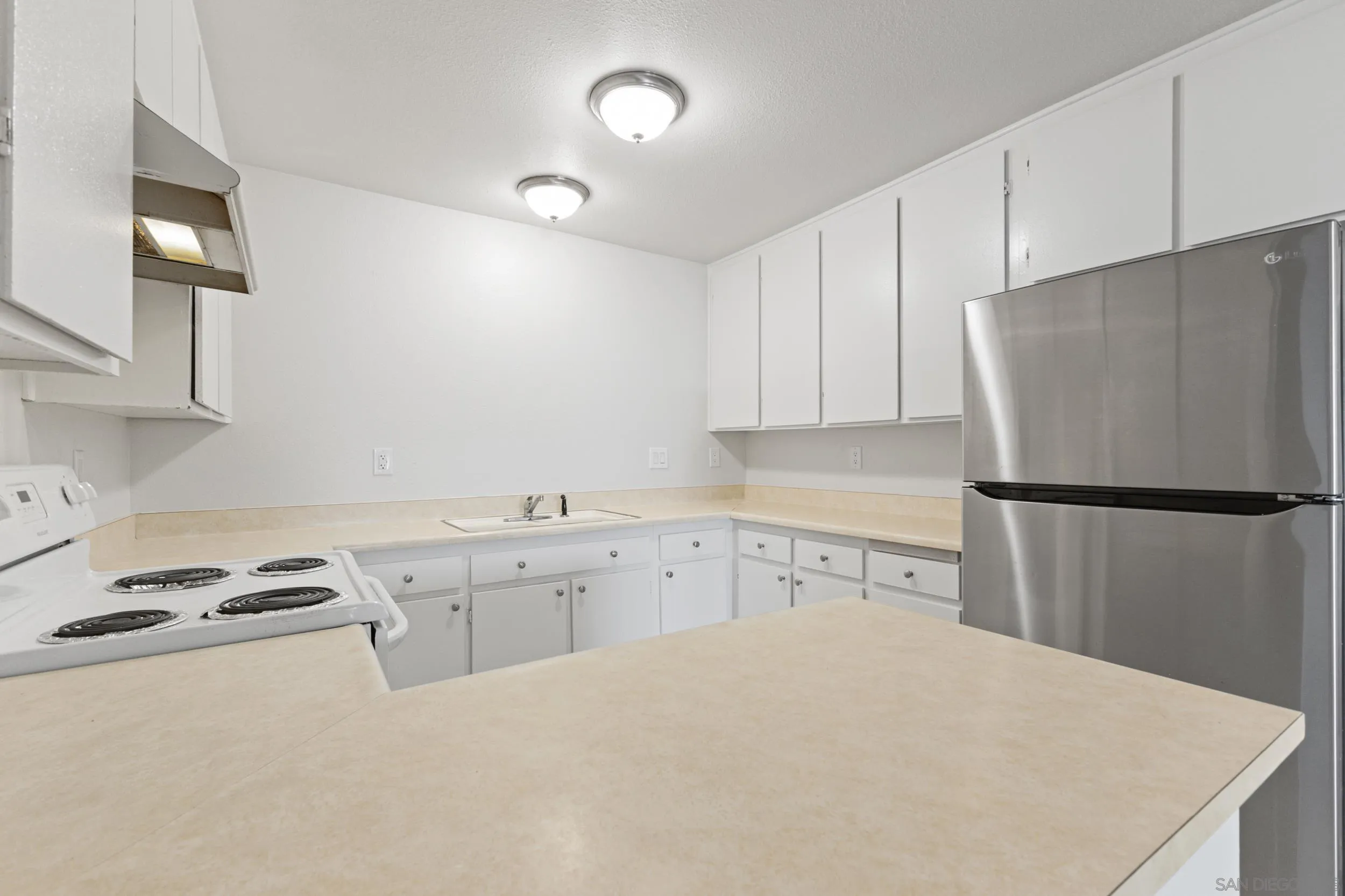 1604 Montecito Road, Unit 20 Ramona, CA 92065 - Photo 3 of 21 a kitchen with a refrigerator a stove a sink and cabinets
