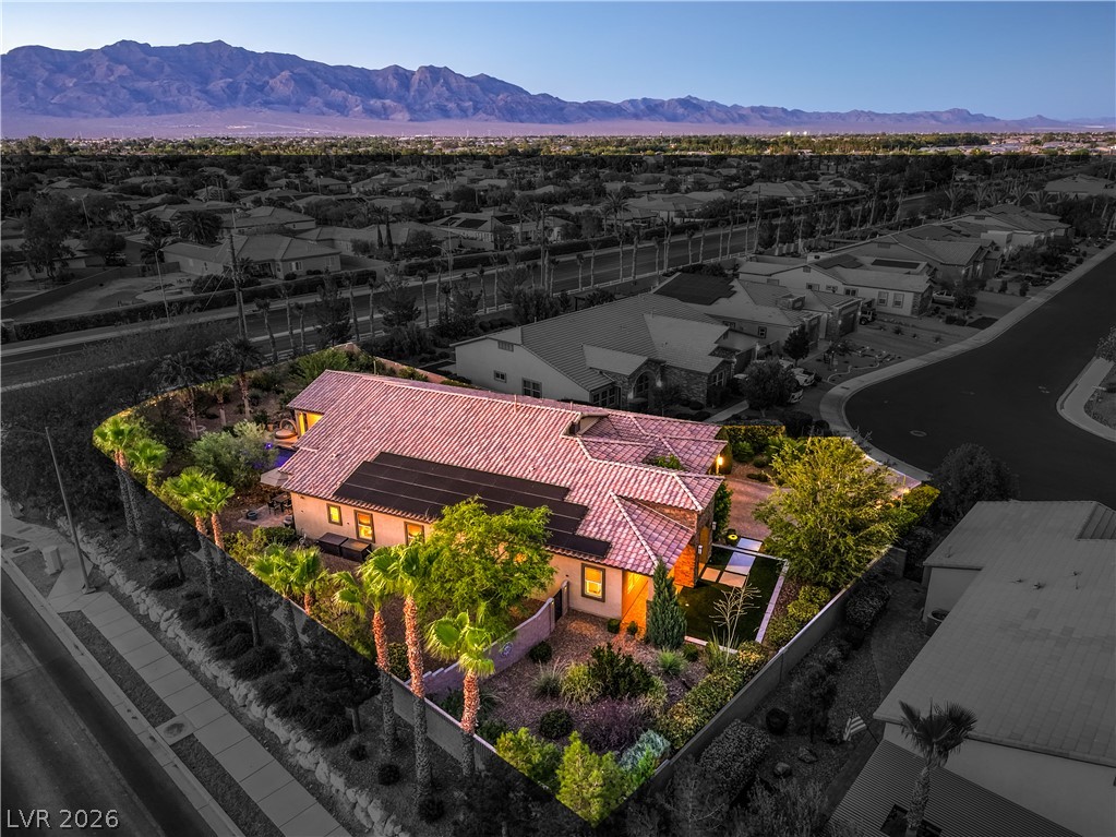 7119 Arabian Ridge Street Las Vegas, NV 89131 - Photo 58 of 73 Illuminated at dusk, this desert oasis showcases a manicured private yard under the mountains.