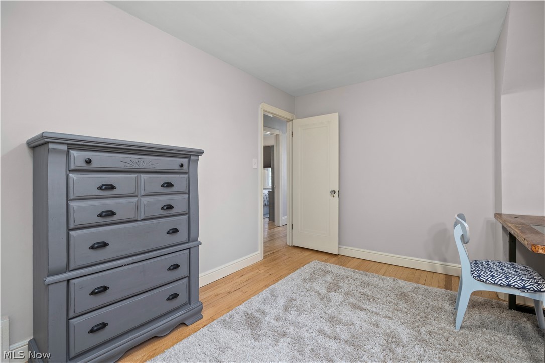 26019 Lake Road Bay Village, OH 44140 - Photo 29 of 40 Room featuring light-toned walls, wood-finish flooring, white baseboards, and a white interior door with dark hardware