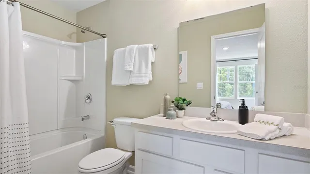 a bathroom with a granite countertop sink a toilet and bathtub