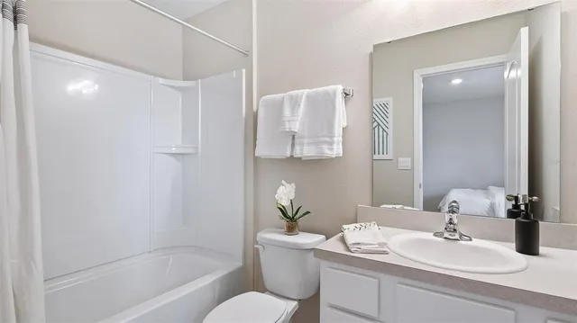 a bathroom with a granite countertop sink a toilet and shower