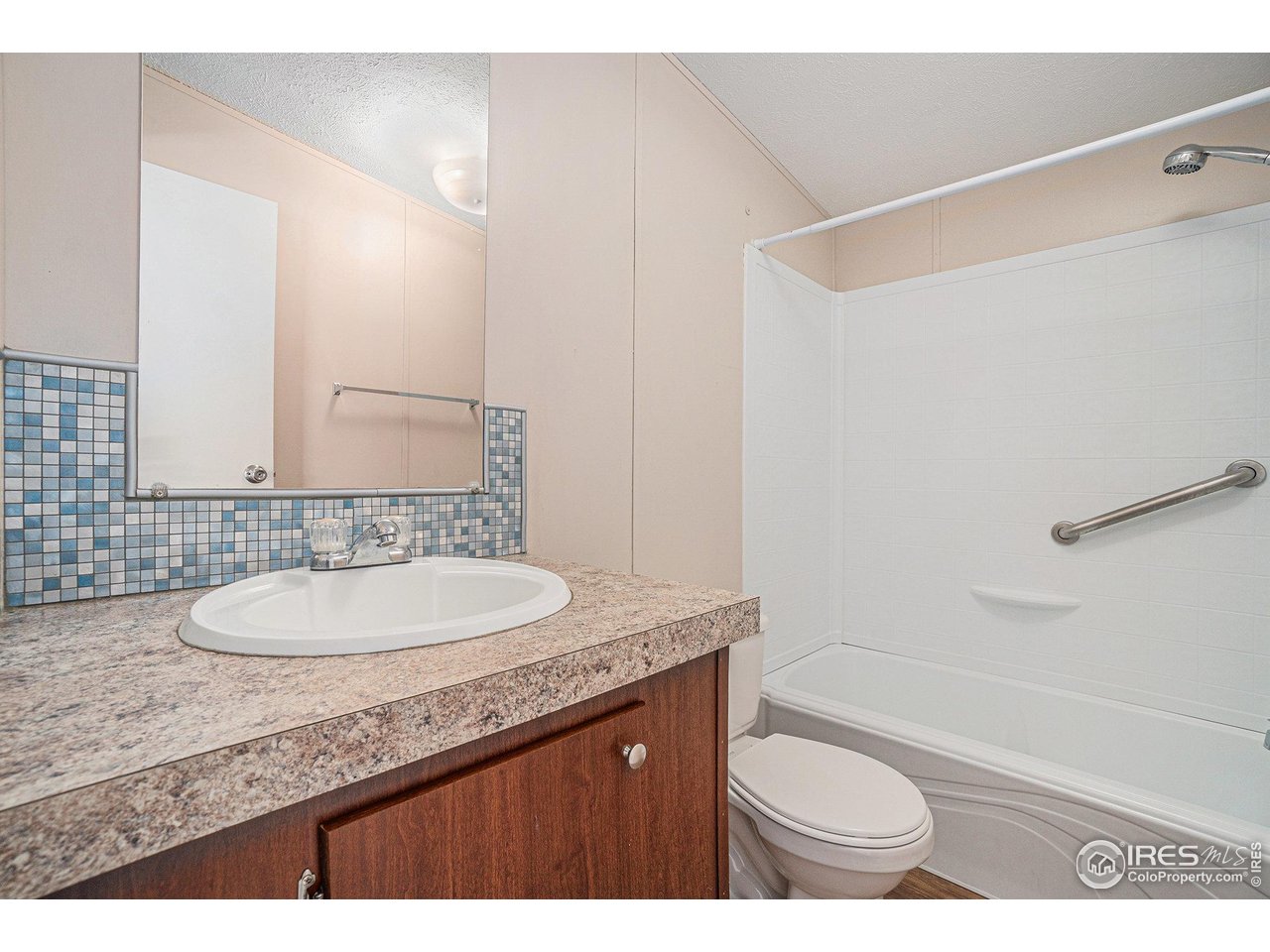 230 North 2nd Street, Unit 76A Berthoud, CO 80513 - Photo 11 of 13 a bathroom with a granite countertop sink a toilet a mirror and bathtub