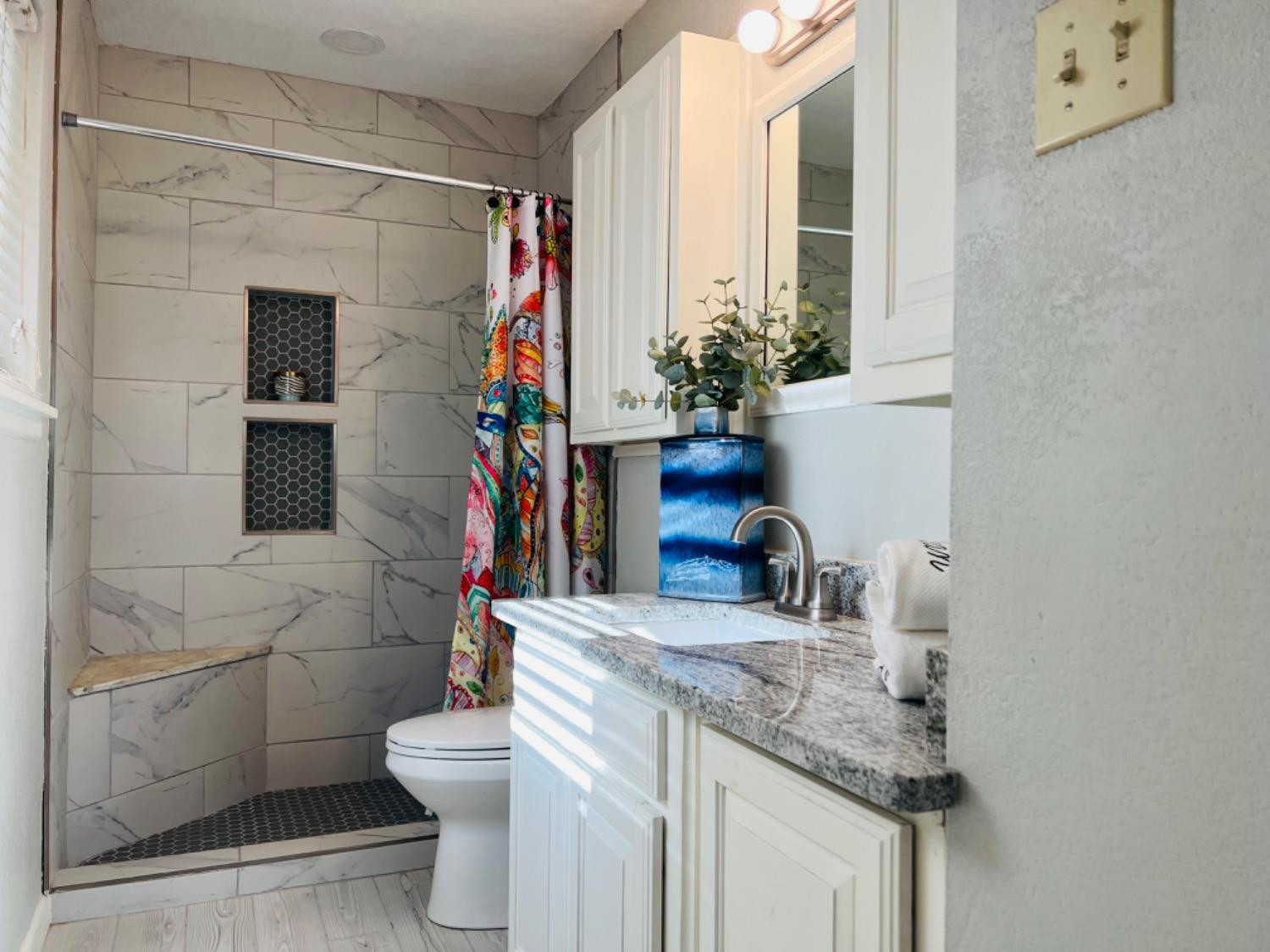 2107 57th Street Lubbock, TX 79412 - Photo 6 of 11 a bathroom with a granite countertop sink a toilet and shower