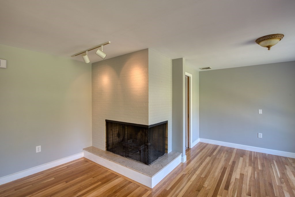 46 Prospect Street Sherborn, MA 01770 - Photo 8 of 40 a view of an empty room with wooden floor and a fireplace