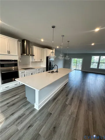 a large white kitchen with wooden floors and a fireplace