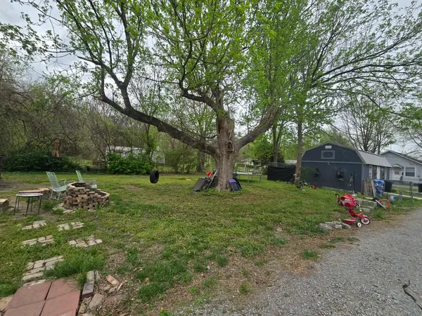 a view of a house with backyard and trees