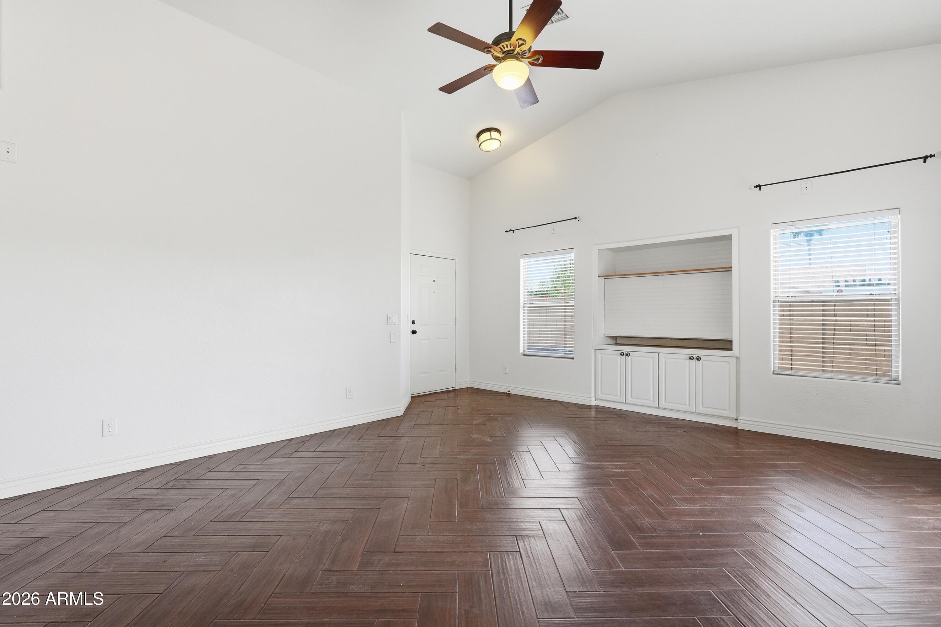 3242 East Bonanza Road Gilbert, AZ 85297 - Photo 10 of 36 an empty room with wooden floor fan and windows