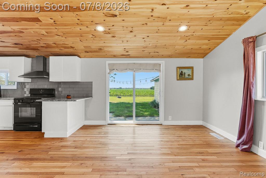 5698 McGrandy Road Bridgeport, MI 48722 - Photo 10 of 26 Open-concept living area featuring wood-finish flooring and a natural wood plank ceiling with recessed lighting