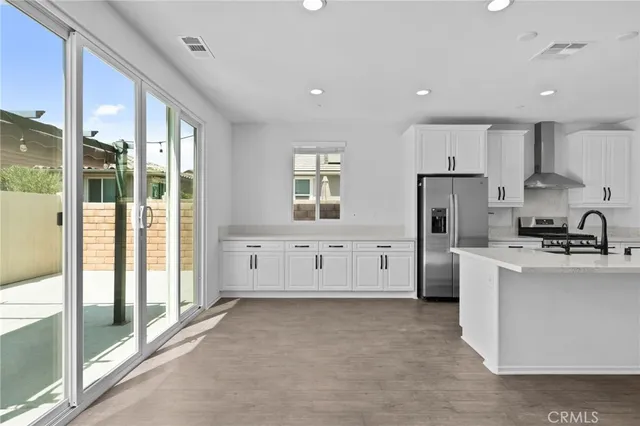 a large white kitchen with stainless steel appliances