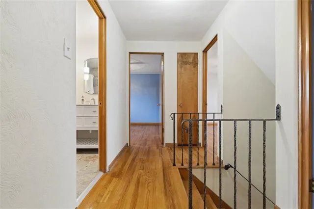 a view of a hallway with wooden floor and staircase