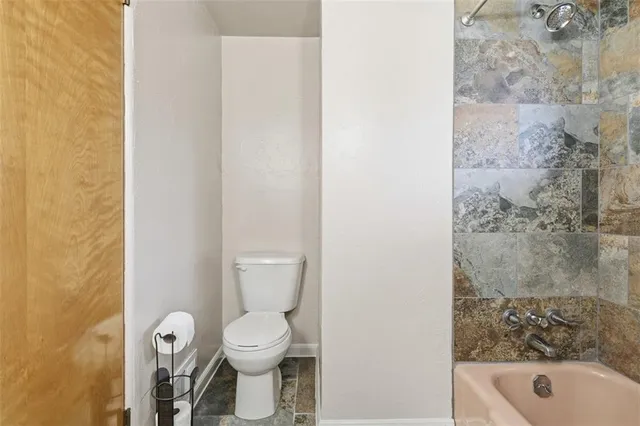 a bathroom with a toilet and a shower