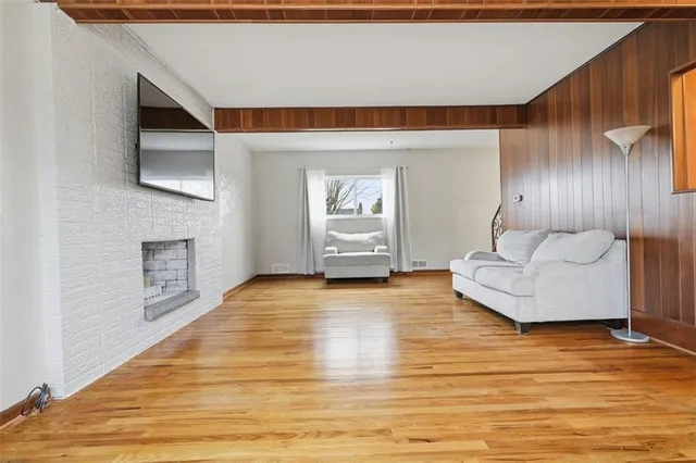 a view of an empty room and kitchen with furniture