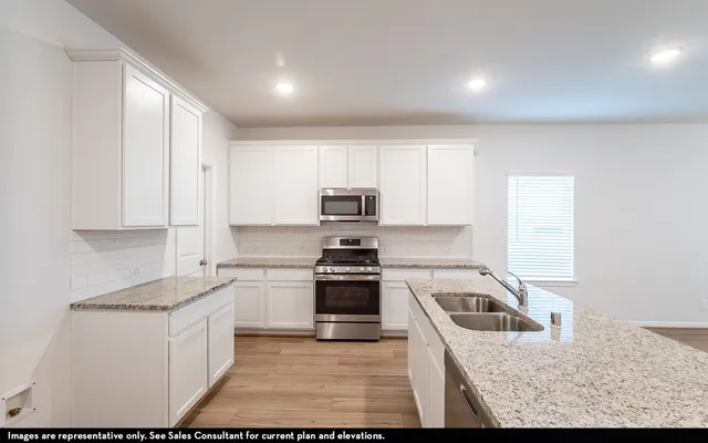 a kitchen with a sink stove and cabinets