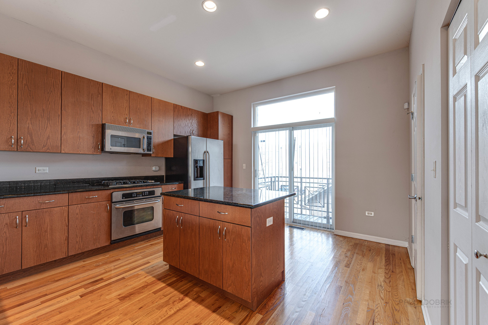 736 West 15th Street Chicago, IL 60607 - Photo 9 of 23 a kitchen with wooden floors and wooden cabinets
