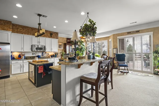 a kitchen with refrigerator and chairs