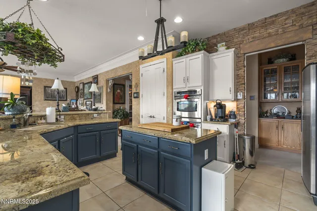 a kitchen with kitchen island granite countertop a sink and a stove
