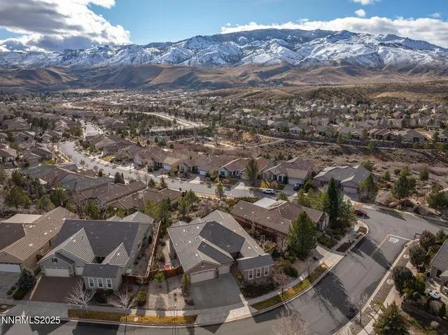 an aerial view of a house with a mountain