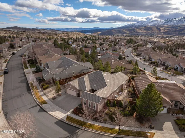 an aerial view of a house with a mountain