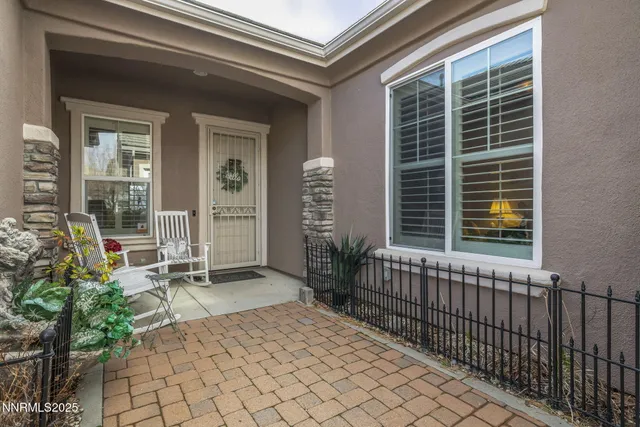 a porch with a bench and a potted plant