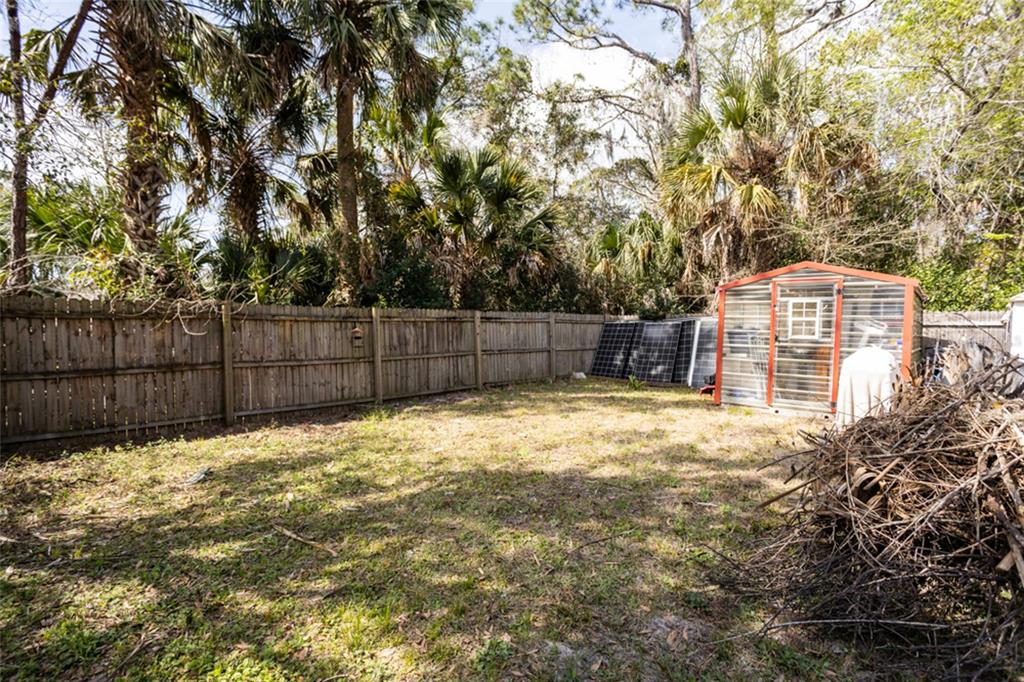 507 South Anderson Street Bunnell, FL 32110 - Photo 12 of 19 a view of a backyard with large trees and wooden fence