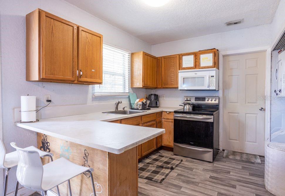 507 South Anderson Street Bunnell, FL 32110 - Photo 3 of 19 a kitchen with stainless steel appliances granite countertop a sink stove and refrigerator