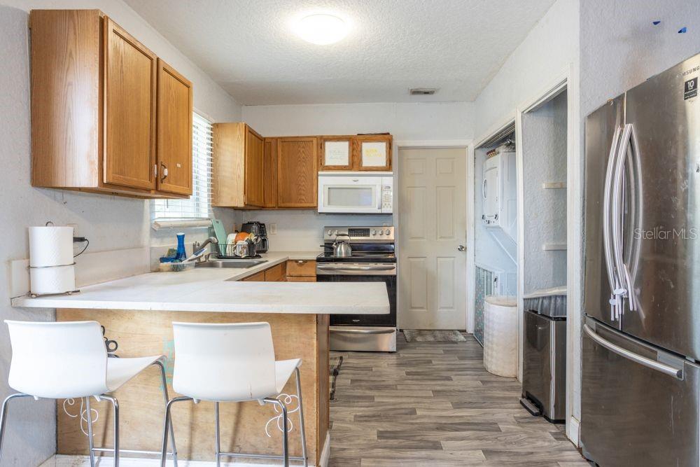 507 South Anderson Street Bunnell, FL 32110 - Photo 4 of 19 a kitchen with stainless steel appliances granite countertop a refrigerator a stove a sink dishwasher and white cabinets with wooden floor