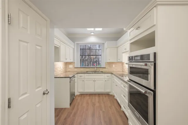 a kitchen with granite countertop stainless steel appliances and white cabinets
