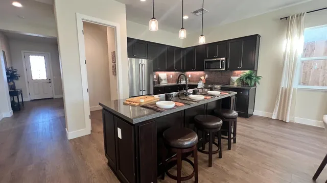 a room with a table chairs and appliances