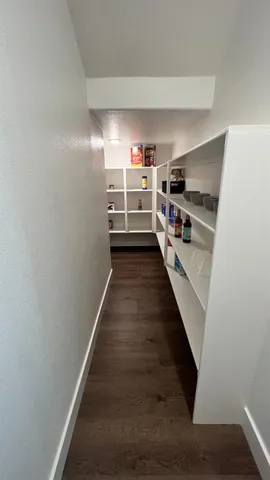 a living room with furniture wooden floor and a large window