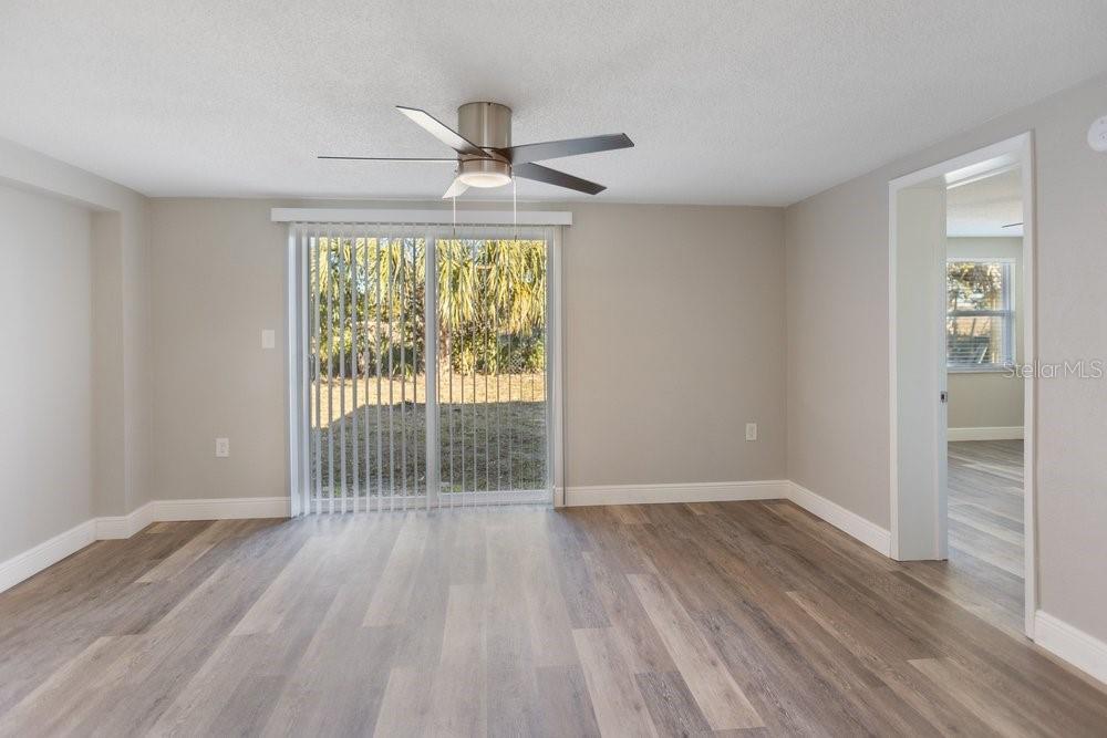 7605 Fox Hollow Drive Port Richey, FL 34668 - Photo 13 of 29 an empty room with wooden floor fan and windows
