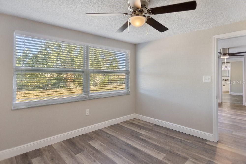 7605 Fox Hollow Drive Port Richey, FL 34668 - Photo 16 of 29 a view of an empty room with a window and wooden floor