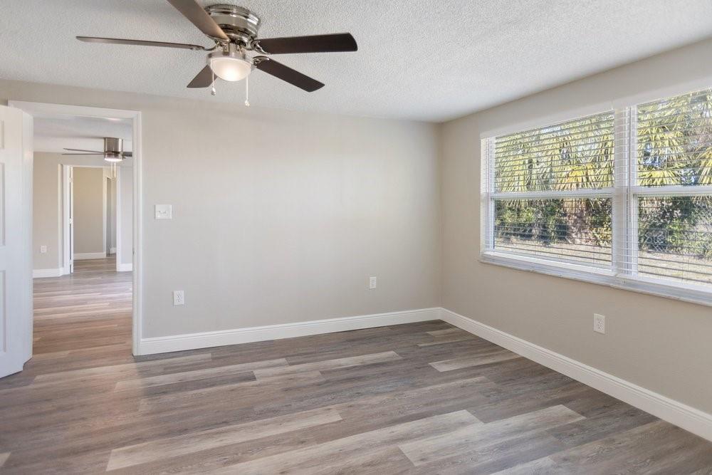 7605 Fox Hollow Drive Port Richey, FL 34668 - Photo 18 of 29 an empty room with wooden floor fan and windows