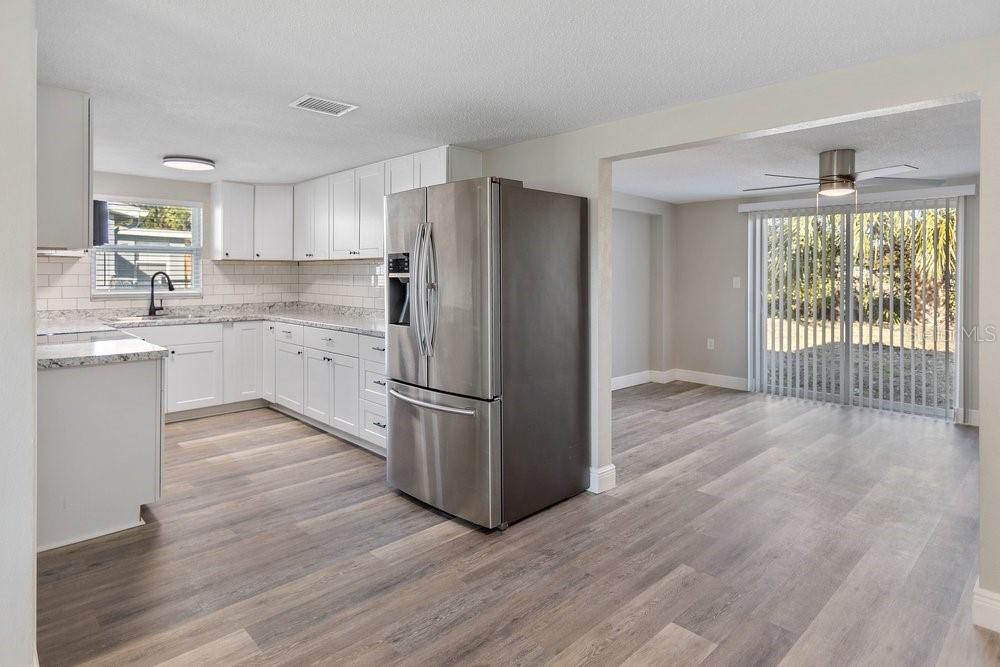 7605 Fox Hollow Drive Port Richey, FL 34668 - Photo 2 of 29 a kitchen with a refrigerator a sink and dishwasher with wooden floor