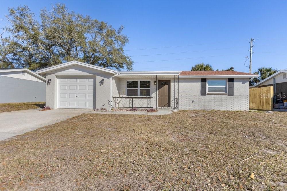 7605 Fox Hollow Drive Port Richey, FL 34668 - Photo 22 of 29 a front view of a house with a yard and garage