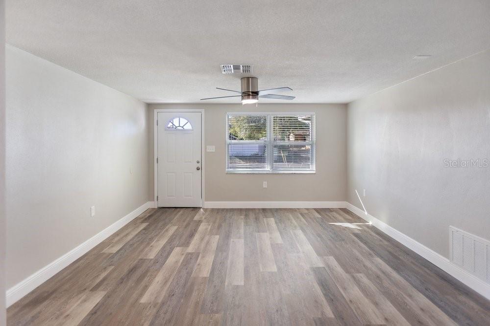 7605 Fox Hollow Drive Port Richey, FL 34668 - Photo 4 of 29 wooden floor in an empty room with a window