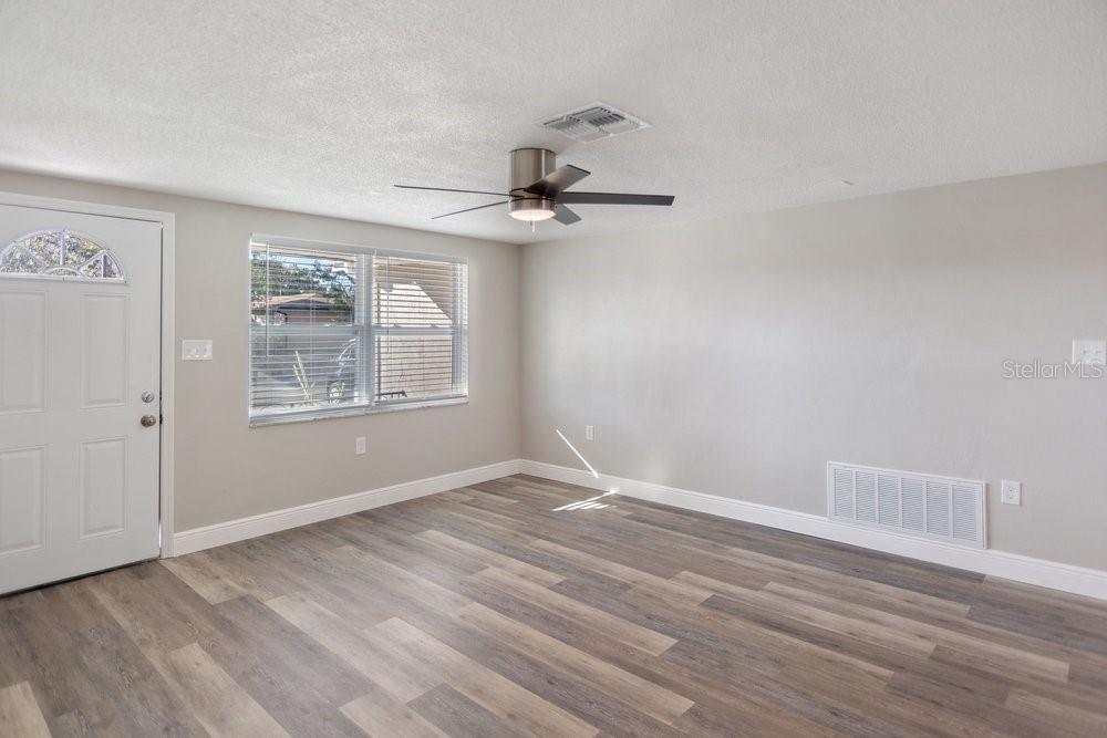 7605 Fox Hollow Drive Port Richey, FL 34668 - Photo 5 of 29 a view of a livingroom with wooden floor a ceiling fan and windows