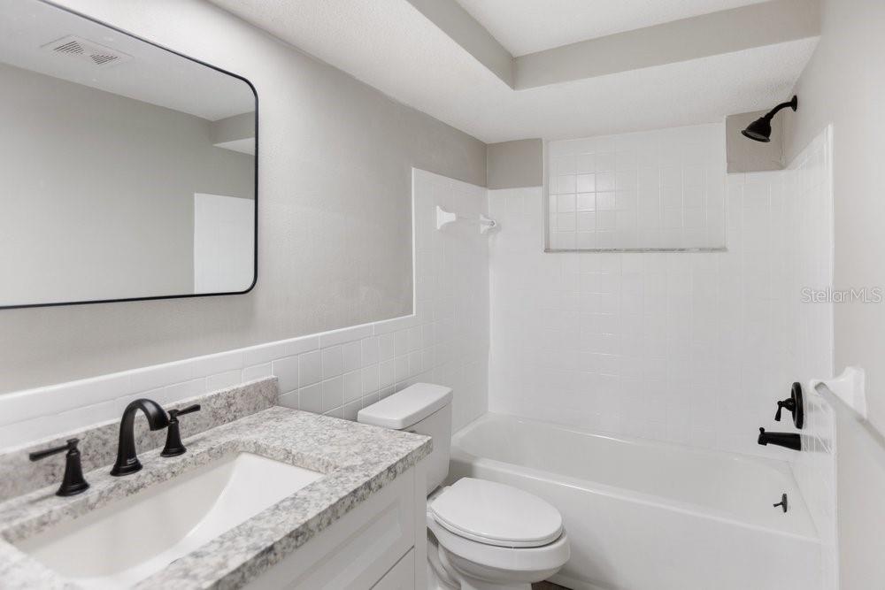 7605 Fox Hollow Drive Port Richey, FL 34668 - Photo 6 of 29 a bathroom with a granite countertop sink toilet and shower