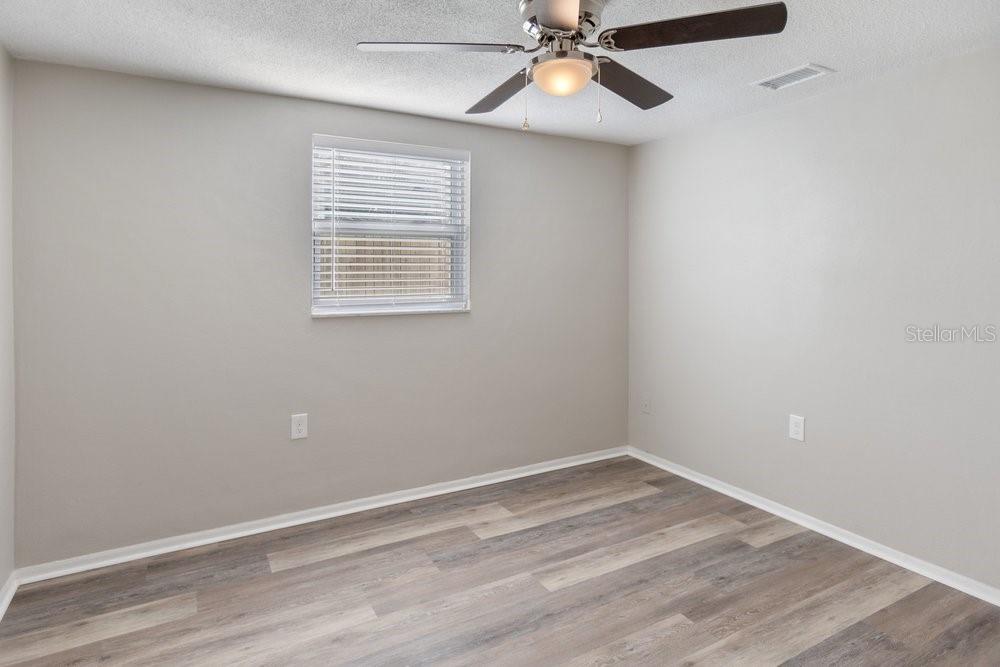 7605 Fox Hollow Drive Port Richey, FL 34668 - Photo 8 of 29 a view of an empty room with a window and wooden floor