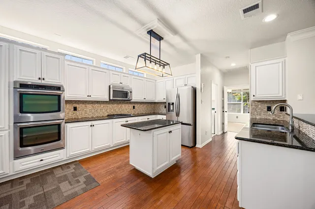 a kitchen with a refrigerator stove and wooden cabinets