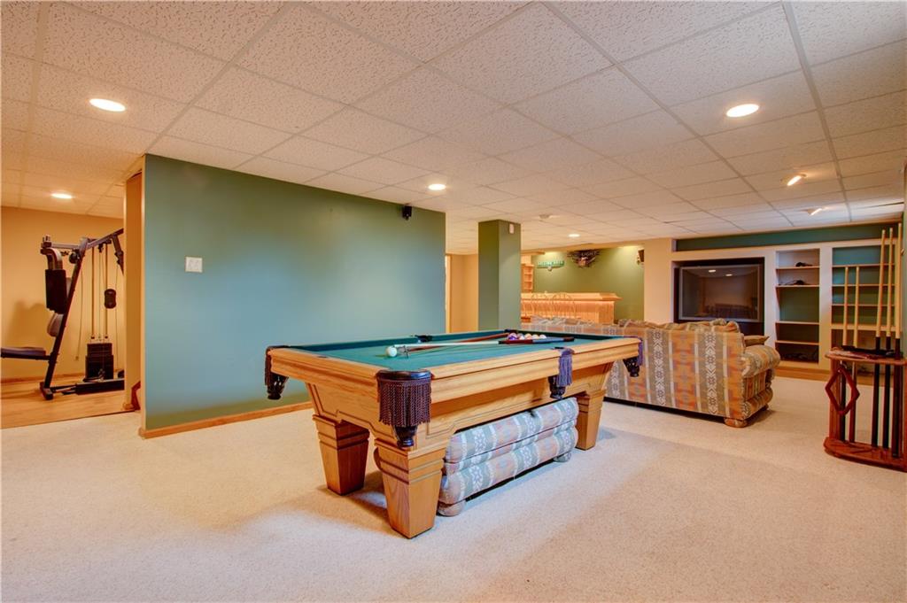 630 Hemlock Road Coraopolis, PA 15108 - Photo 25 of 25 Finished basement area showing the built in cabinets/entertainment area and custom wet bar with beer refrigerator. On the left an exercise room/office/playroom. There is another half bath and laundry room in the basement that are not shown.