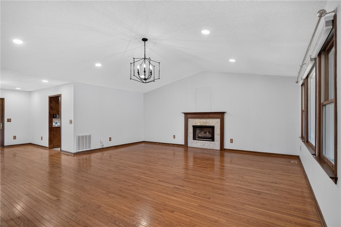 103 Dorsey Lane Walhalla, SC 29691 - Photo 4 of 42 Generous living area featuring gleaming hardwood floors, vaulted ceilings, and a cozy fireplace with a marble surround.