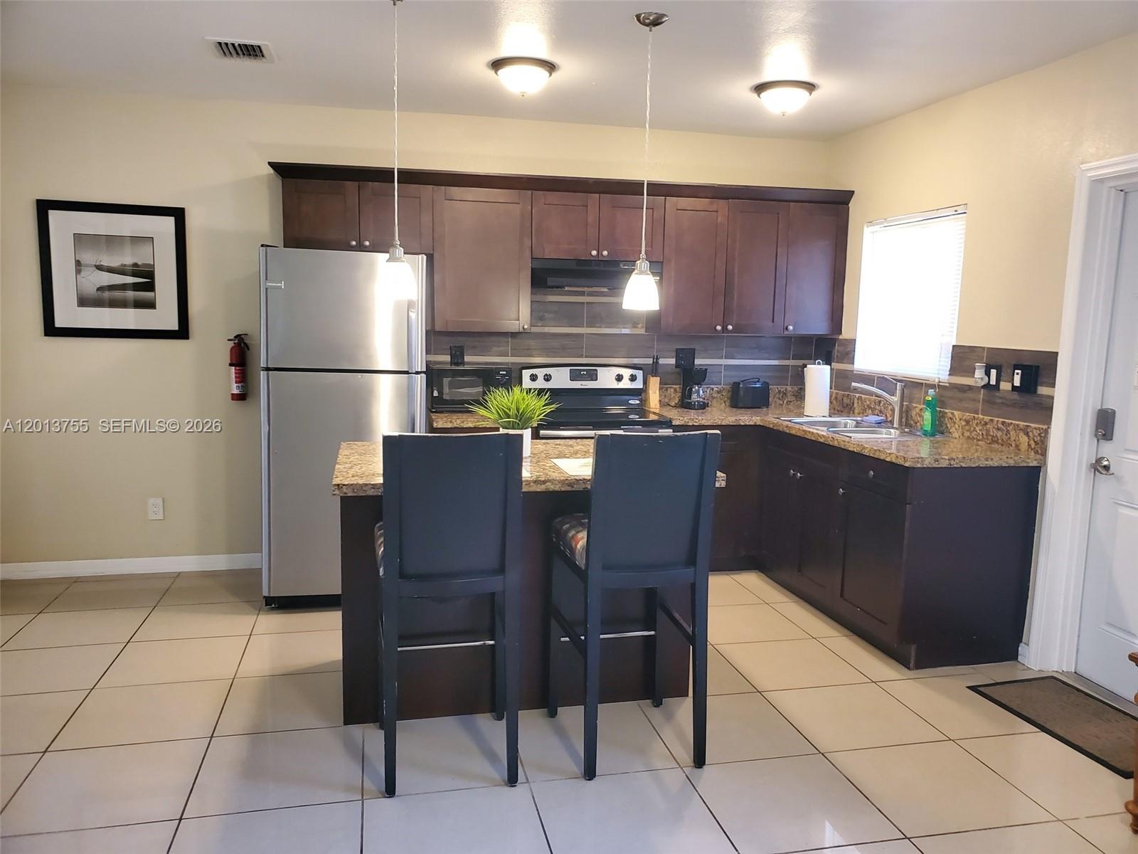 2015 Funston Street, Unit 2 Hollywood, FL 33020 - Photo 12 of 19 a kitchen with stainless steel appliances granite countertop a refrigerator and a stove top oven